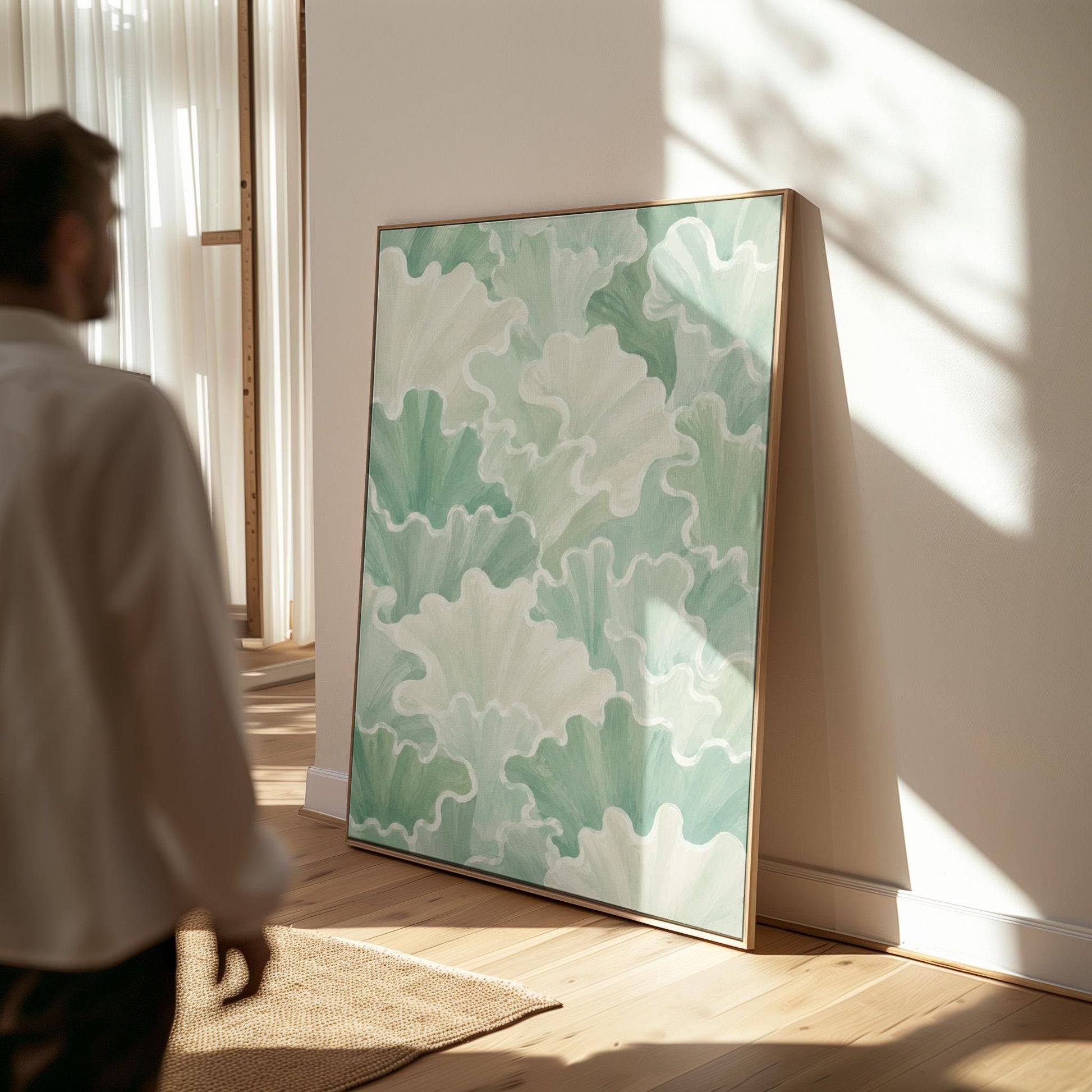Fan shaped leafy forms in soft sage green watercolor, canvas wall art hanging in a calm, modern living space