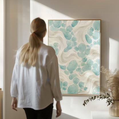 Aqua pebble shapes drifting among soft cream waves, canvas wall art seen in a warm interior with natural light