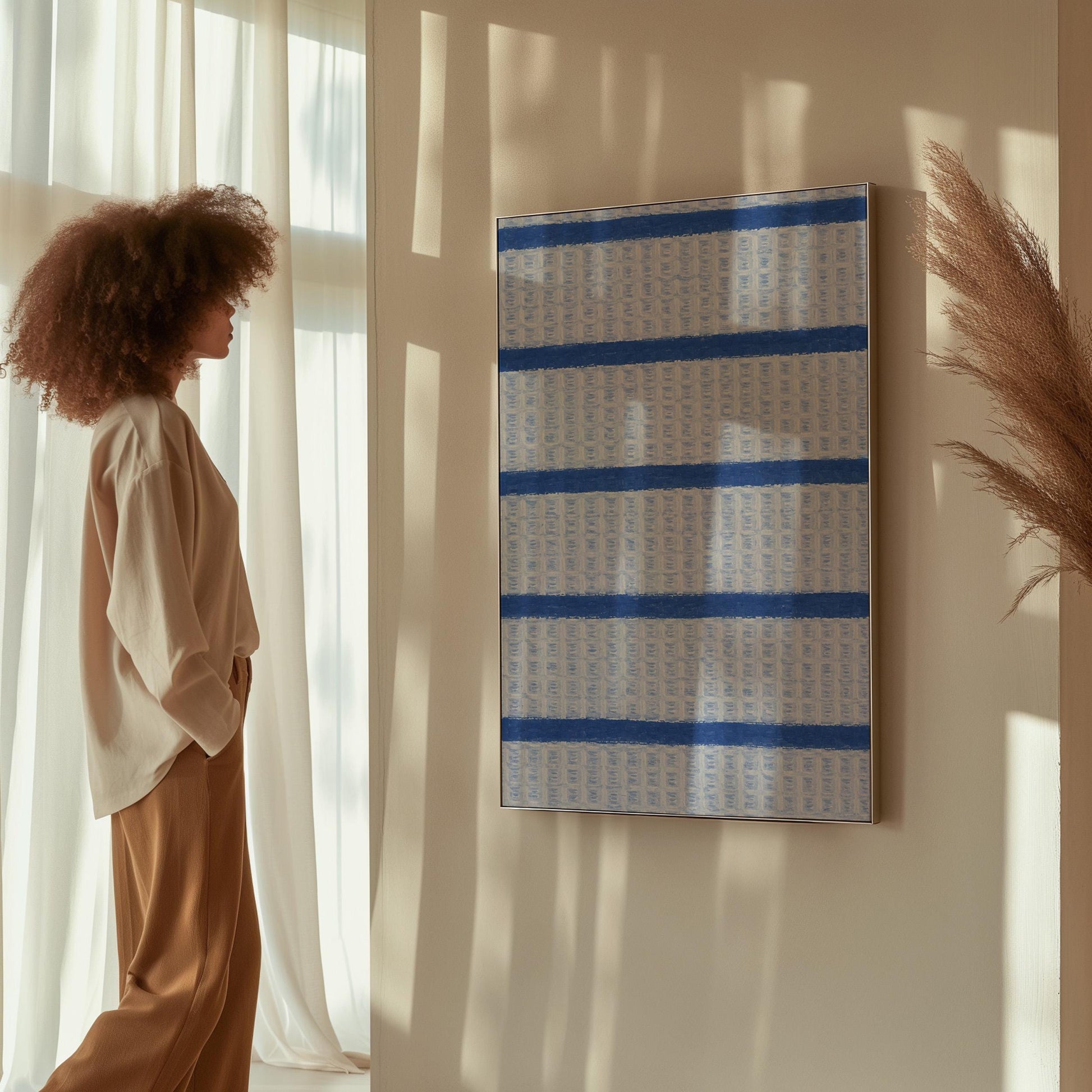 Bold cornflower blue stripes on a pale blue background, canvas print seen in a warm interior with natural light