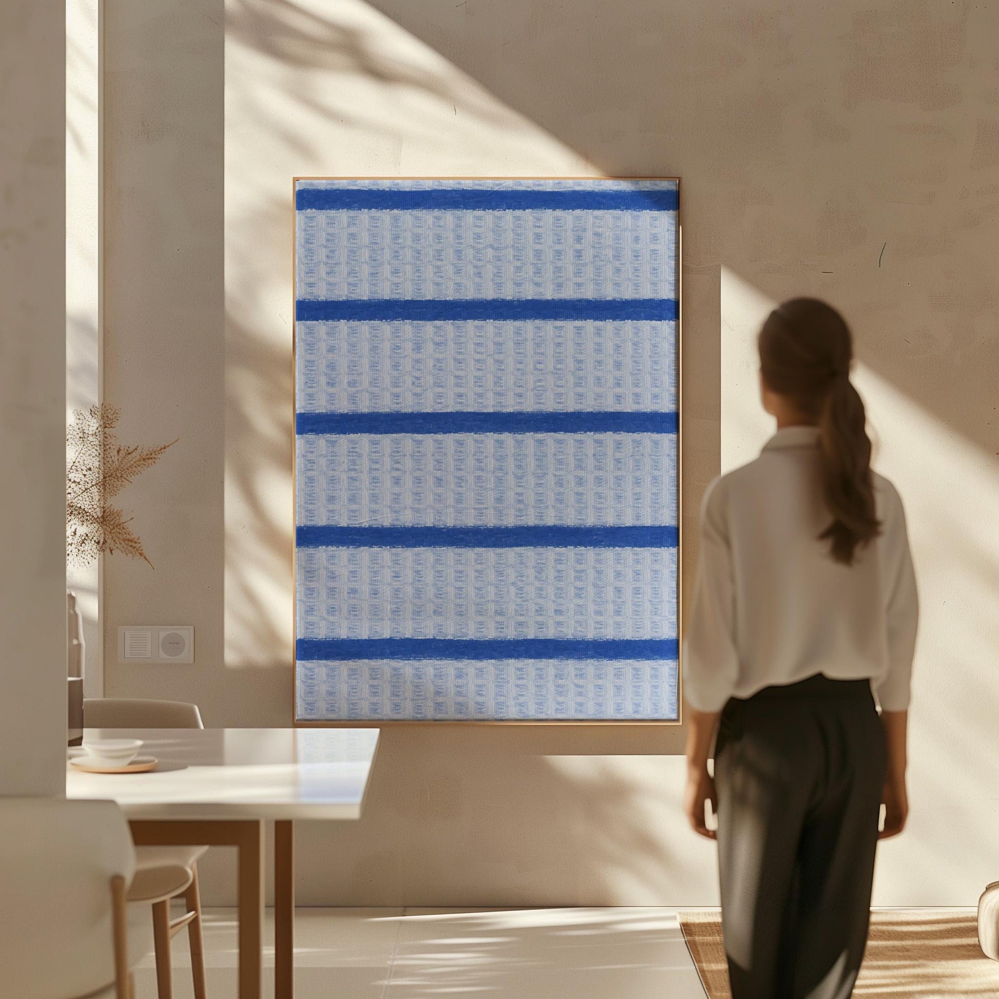 Bold cornflower blue stripes on a pale blue background, canvas wall art styled against a soft white wall