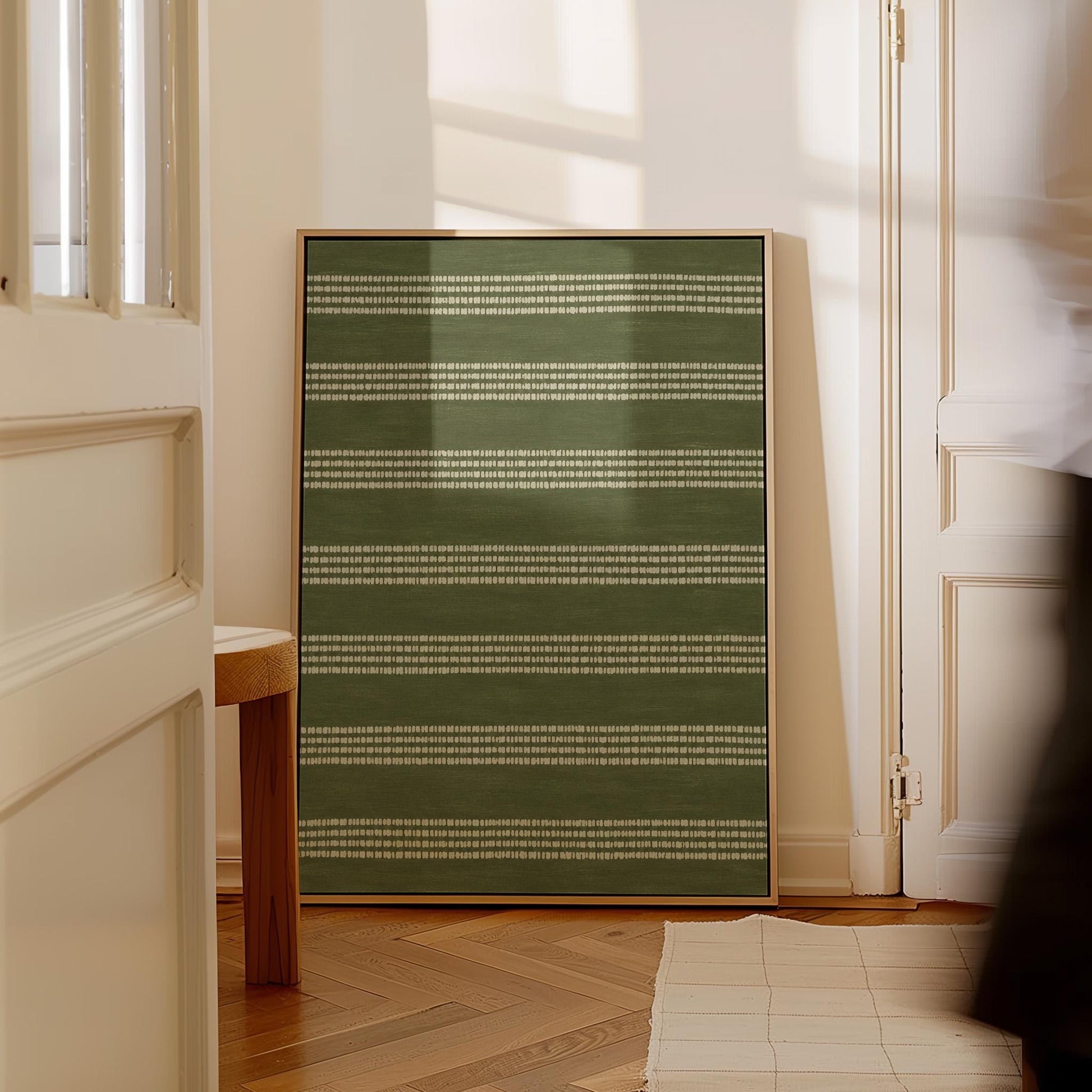 Olive green field with thin cream pinstripe rows, canvas print shown to scale in a furnished room
