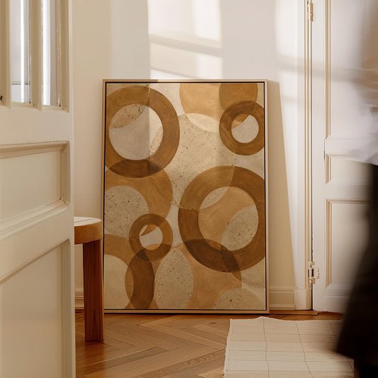 Overlapping translucent circles in amber and terracotta, canvas print hanging in a calm, modern living space