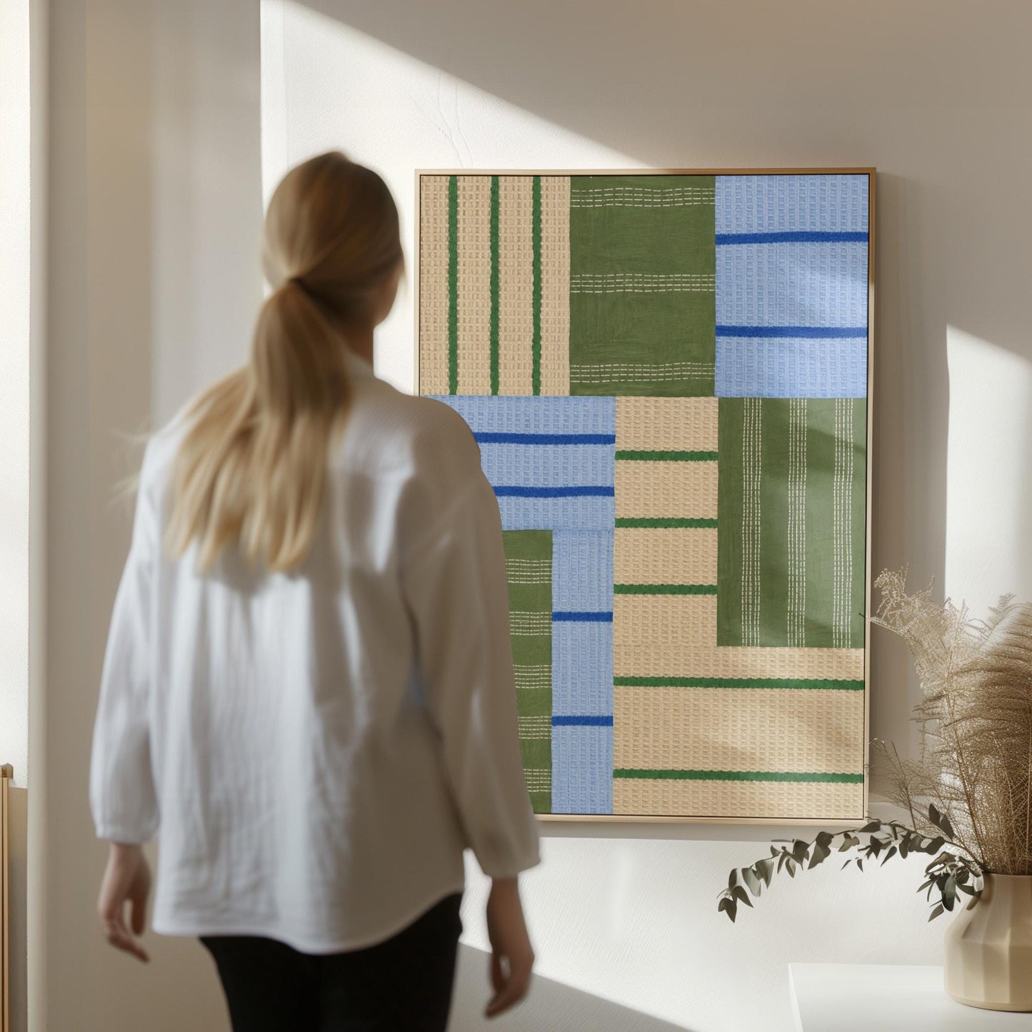 Patchwork of sage green fields with periwinkle blue bands, canvas print seen in a warm interior with natural light