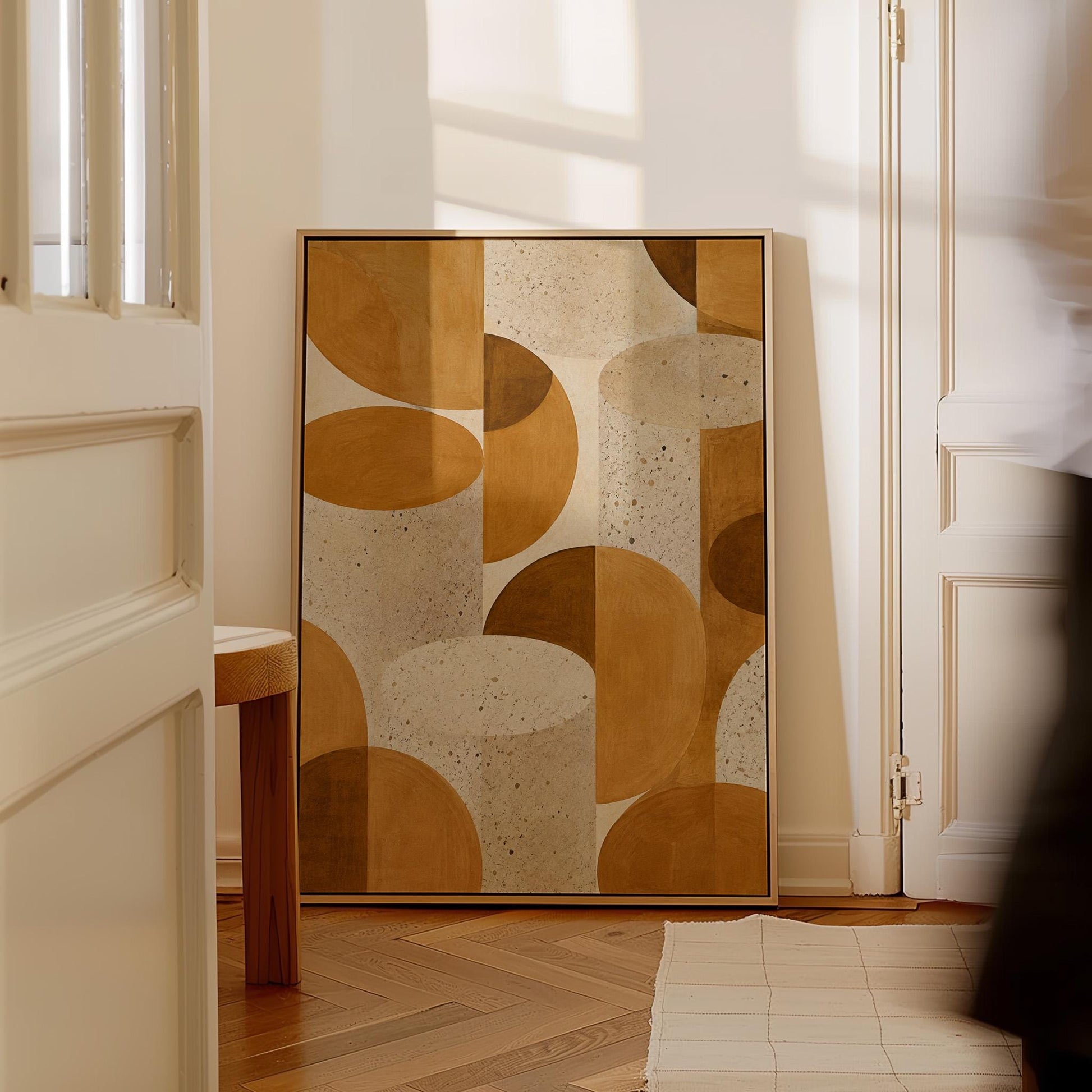 Warm caramel geometric shapes on speckled cream background, canvas print hanging in a calm, modern living space