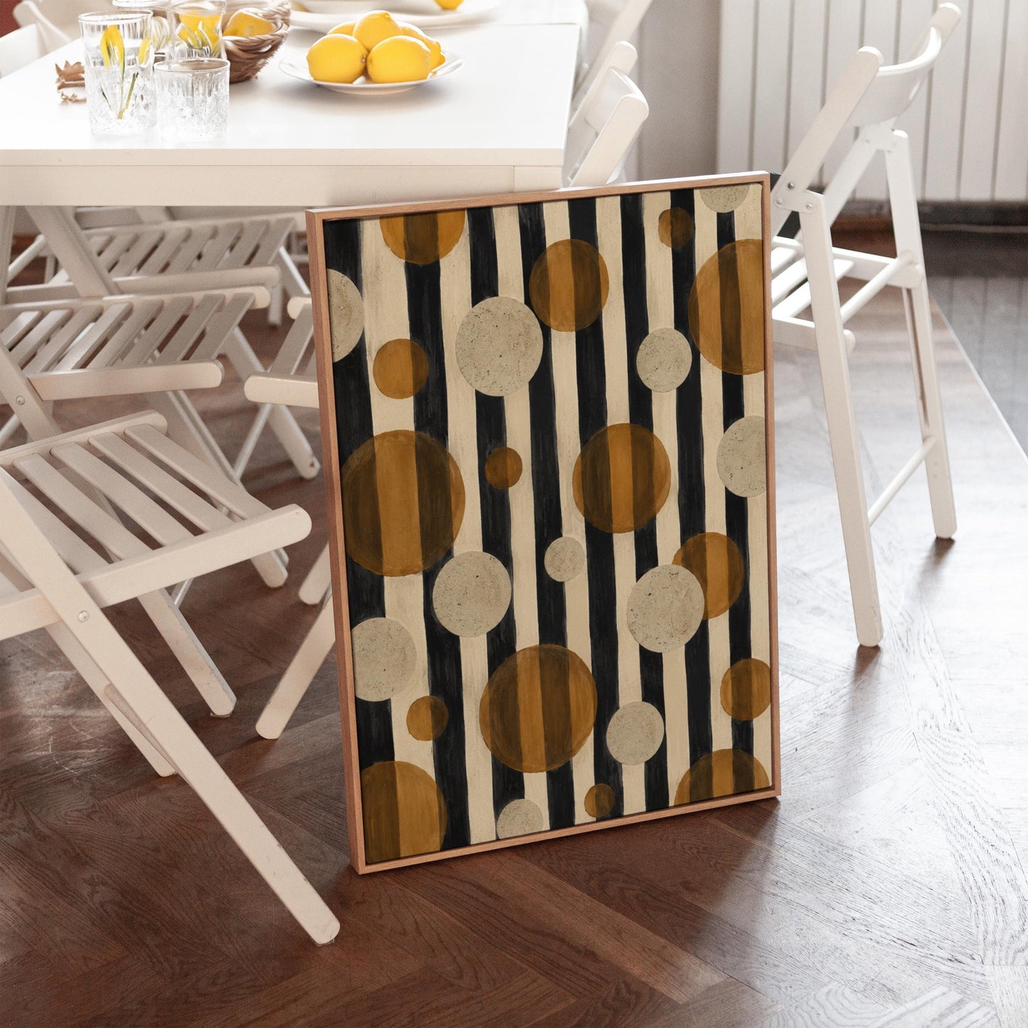 Amber and cream circles scattered over black vertical stripes, canvas print shown in a sunlit, contemporary room