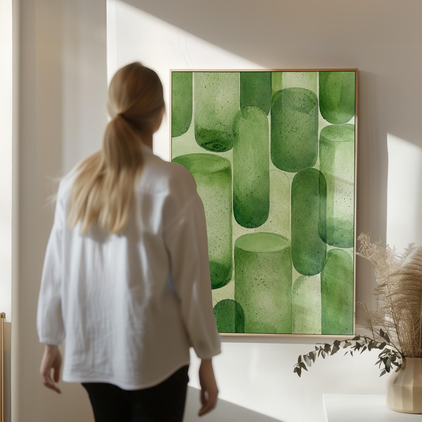 Rounded capsule shapes in layered watercolor greens, canvas print styled against a soft white wall