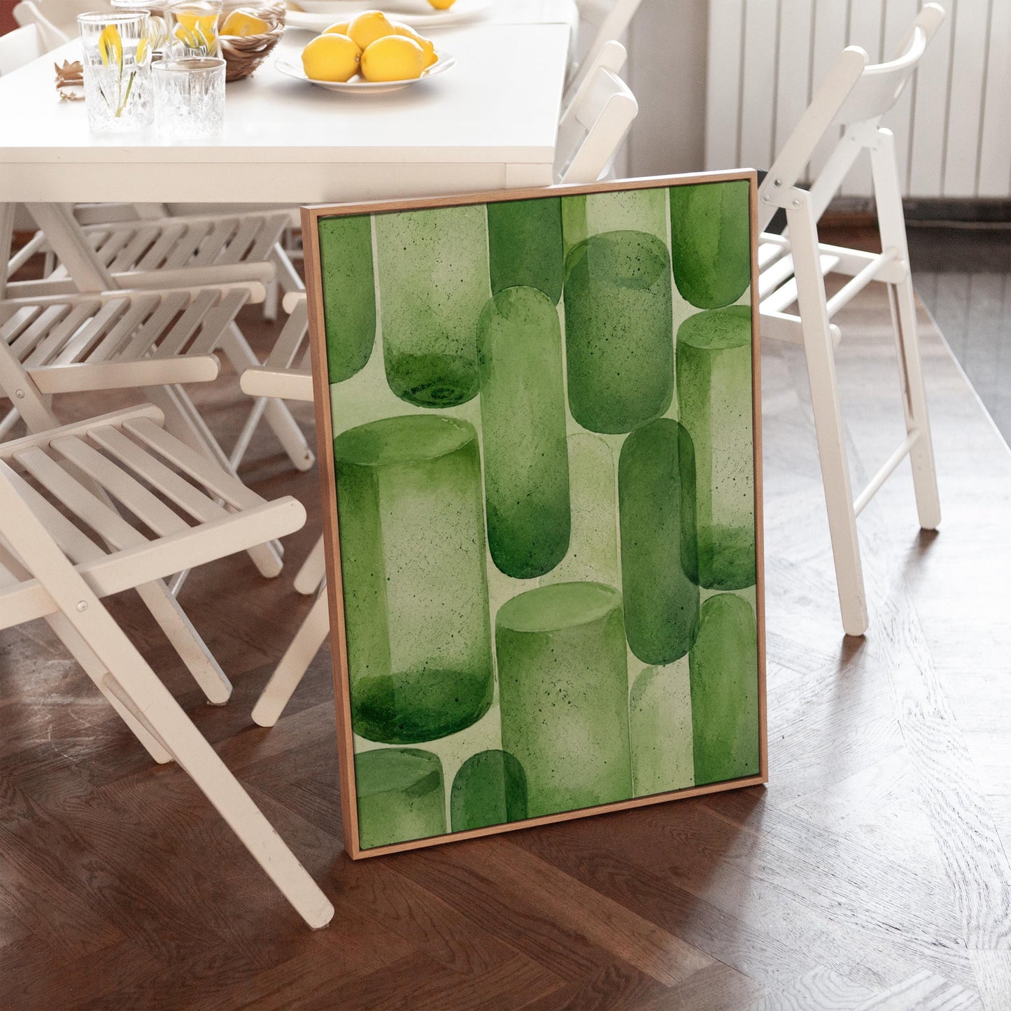 Rounded capsule shapes in layered watercolor greens, canvas wall art seen in a warm interior with natural light
