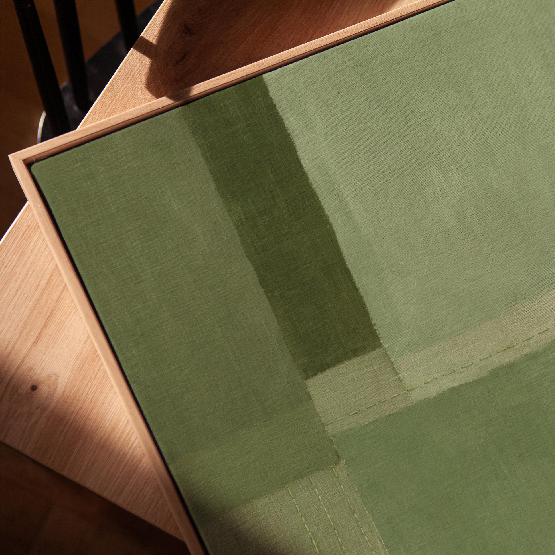 Tonal color blocks in muted sage and olive green, canvas print in a warm, minimally styled interior