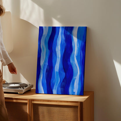 Vertical flowing ribbons in cobalt and light blue, canvas wall art hanging in a calm, modern living space