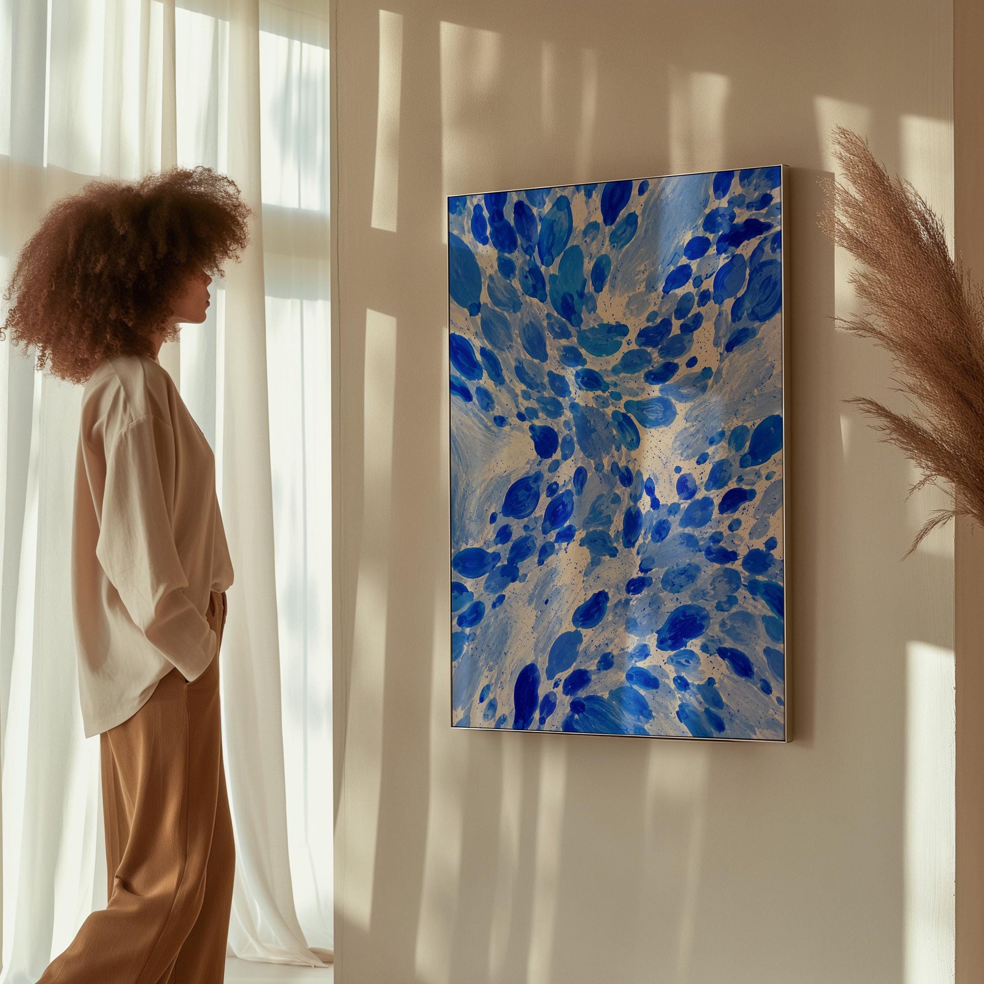 Burst of cobalt blue droplets scattering across pale background, canvas print on a quiet wall in a considered interior