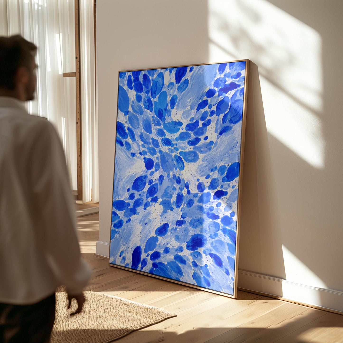 Burst of cobalt blue droplets scattering across pale background, canvas print shown in a sunlit, contemporary room