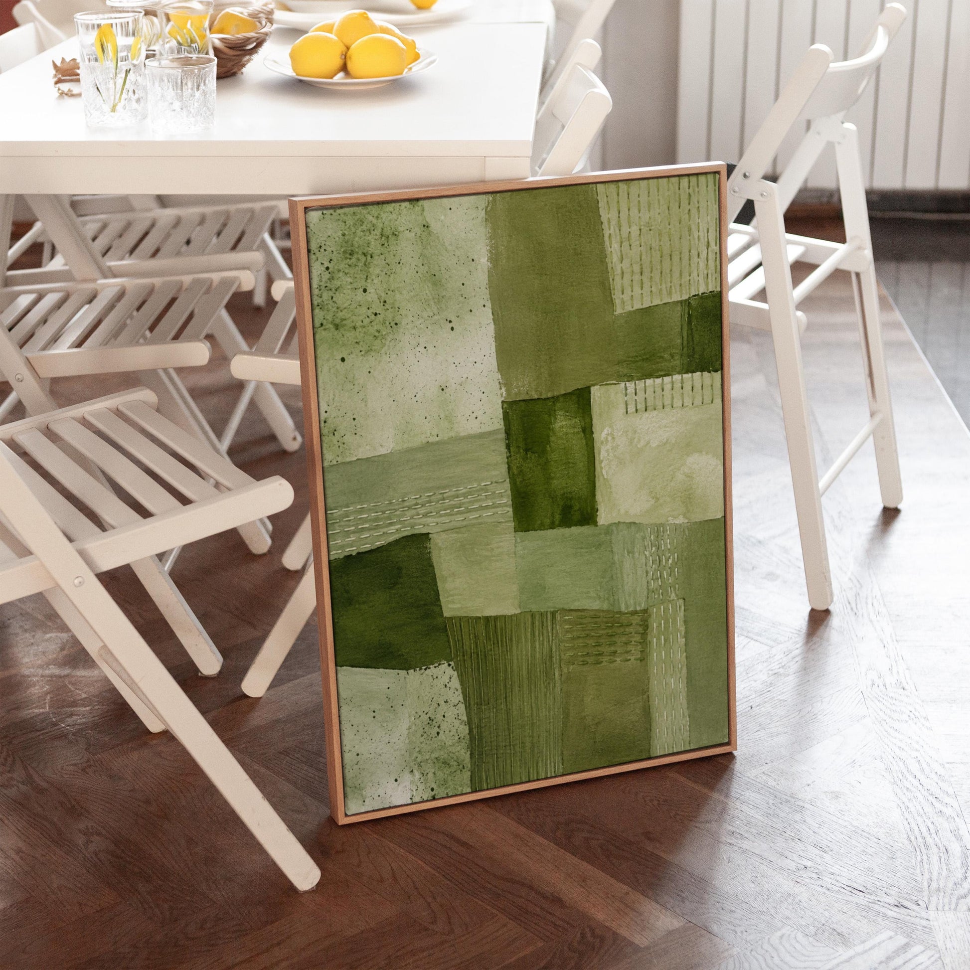 Patchwork of olive and moss green field blocks, canvas print on a quiet wall in a considered interior