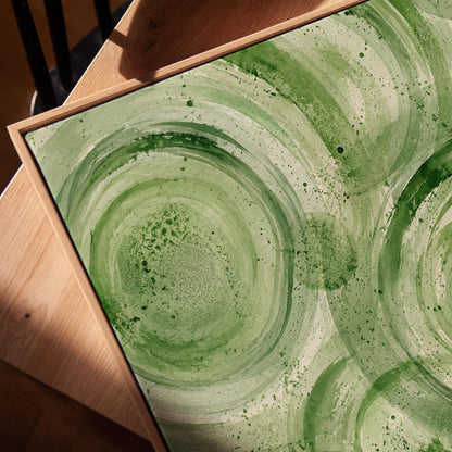 Concentric ripple rings in soft watercolor greens, canvas print in a warm, minimally styled interior