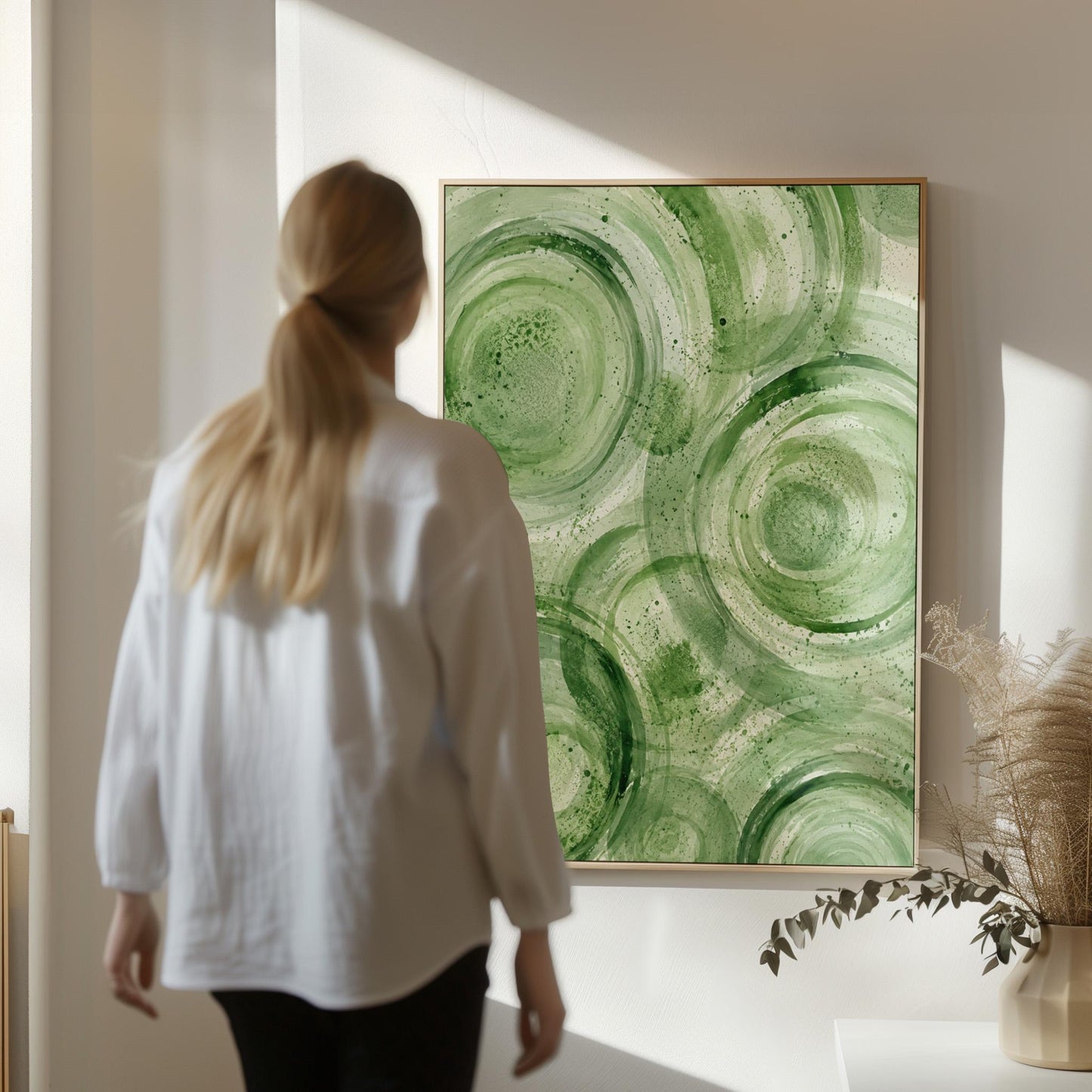 Concentric ripple rings in soft watercolor greens, canvas wall art on a quiet wall in a considered interior