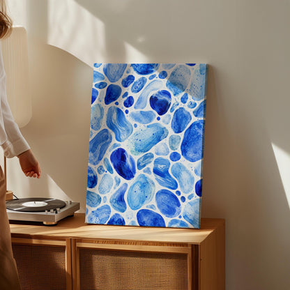 Watercolor pebbles in shades of sky blue and cobalt, canvas print styled against a soft white wall