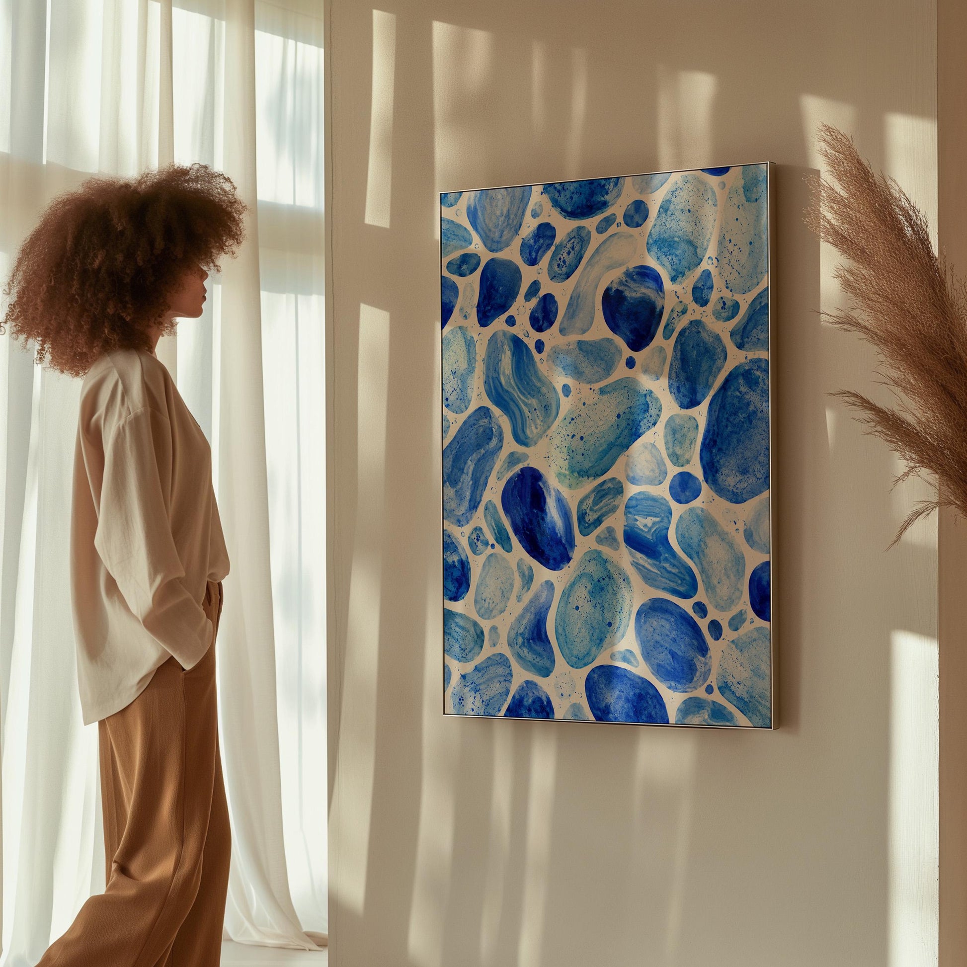 Watercolor pebbles in shades of sky blue and cobalt, canvas print seen in a warm interior with natural light