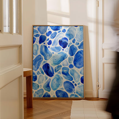 Watercolor pebbles in shades of sky blue and cobalt, canvas print shown to scale in a furnished room