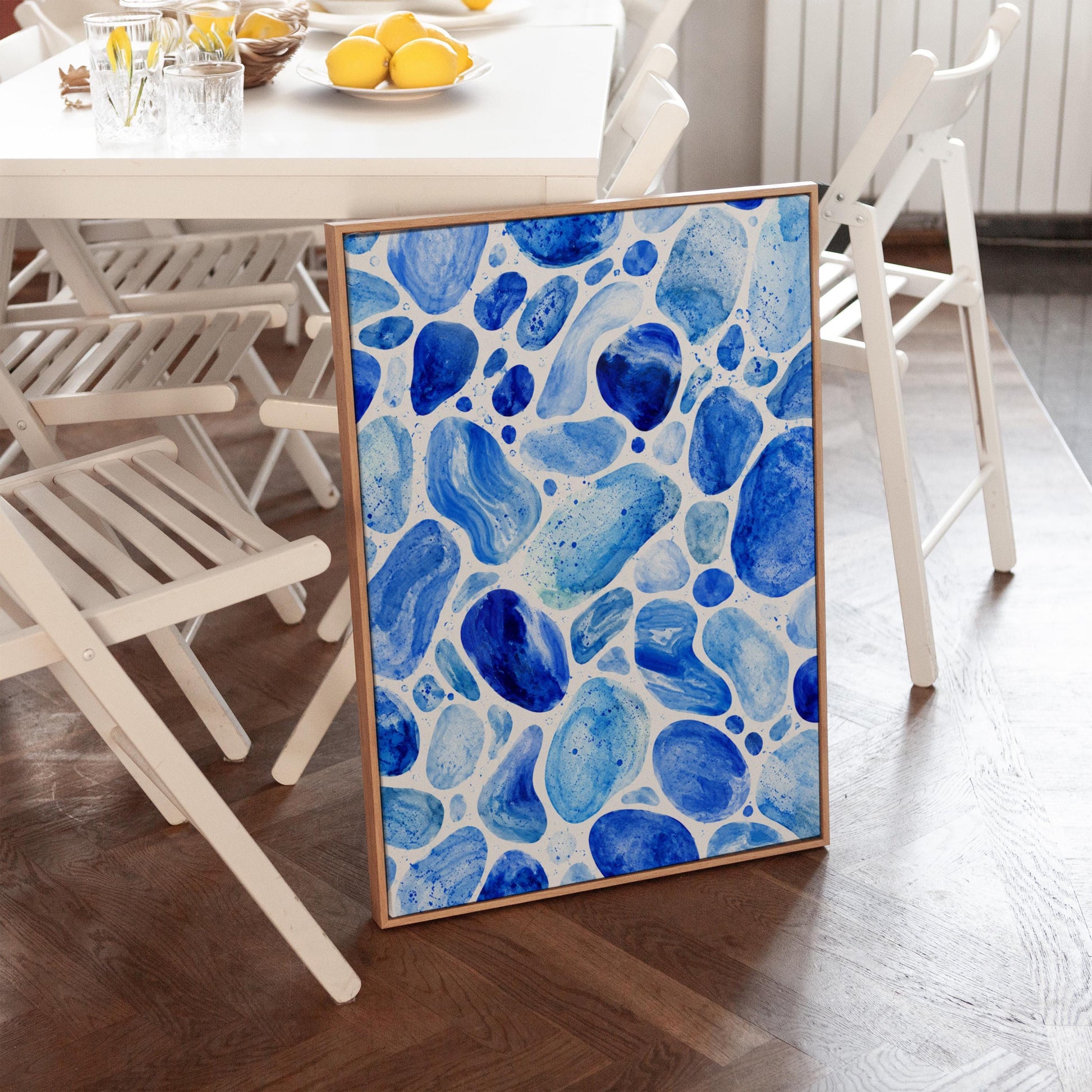Watercolor pebbles in shades of sky blue and cobalt, canvas print shown in a sunlit, contemporary room