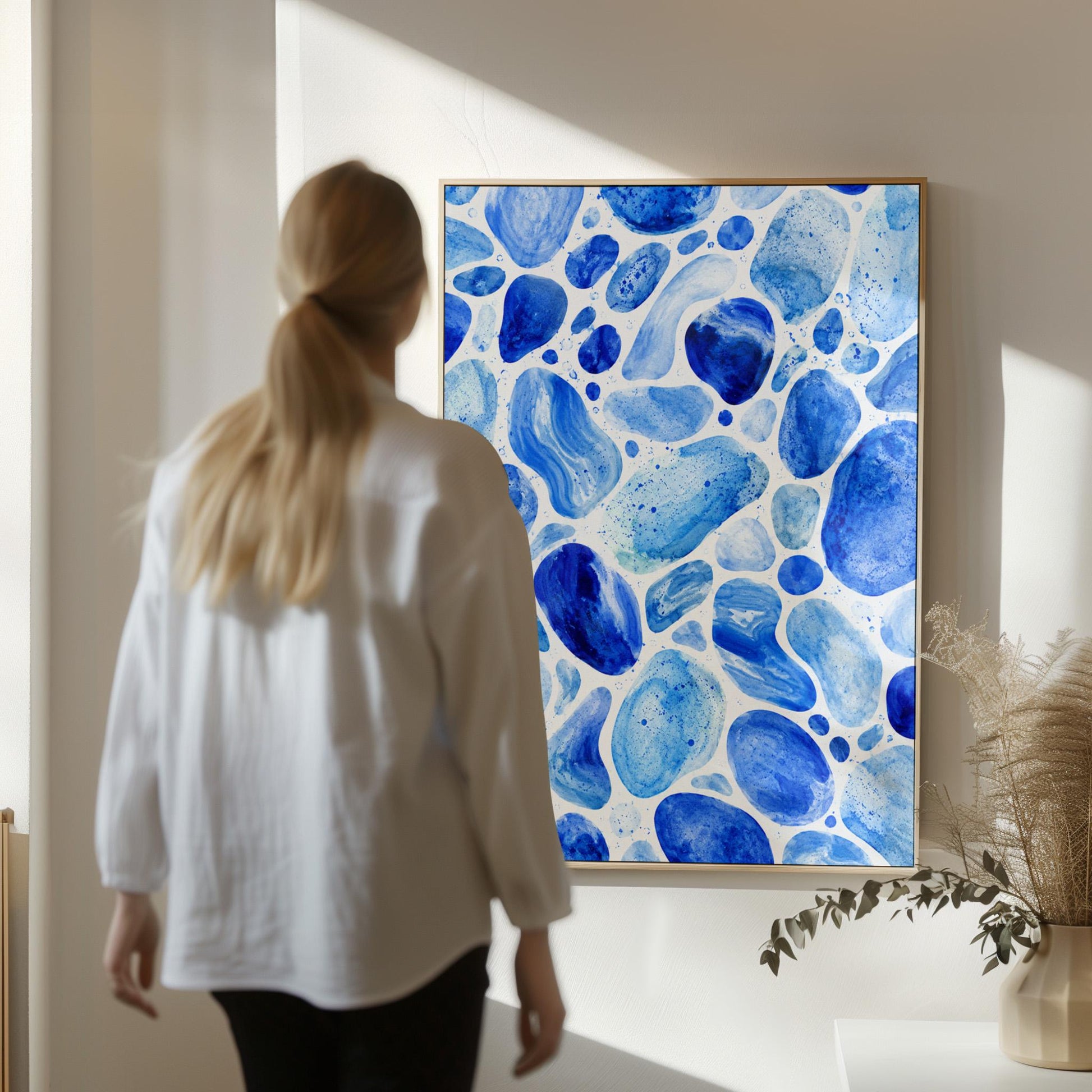 Watercolor pebbles in shades of sky blue and cobalt, canvas wall art on a quiet wall in a considered interior