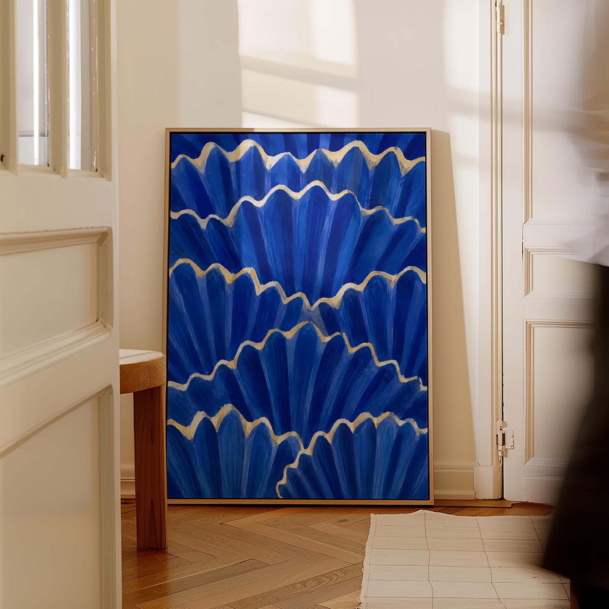Fan shaped scallop shells in cobalt with gold edges, canvas wall art on a quiet wall in a considered interior