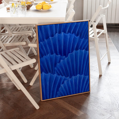 Overlapping pleated fan shapes in deep royal blue, canvas print shown to scale in a furnished room