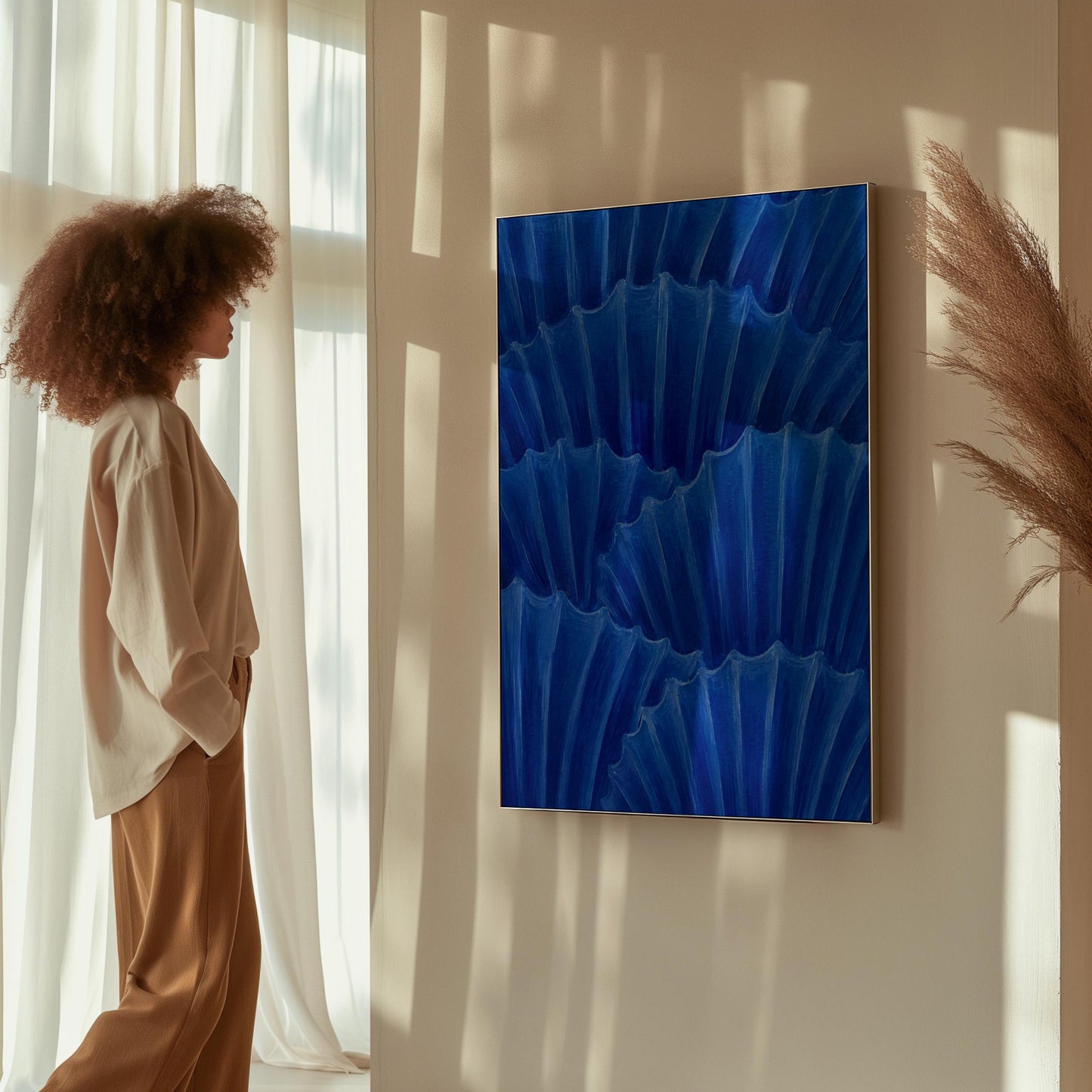Overlapping pleated fan shapes in deep royal blue, canvas wall art presented in a light, minimal room