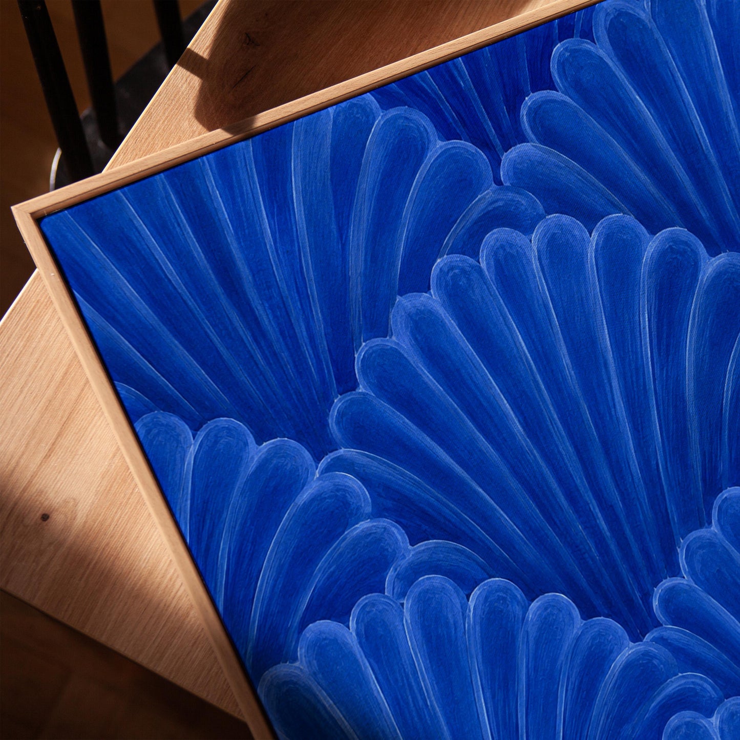 Fan shaped shell scales pattern in sapphire blue, canvas print in a warm, minimally styled interior