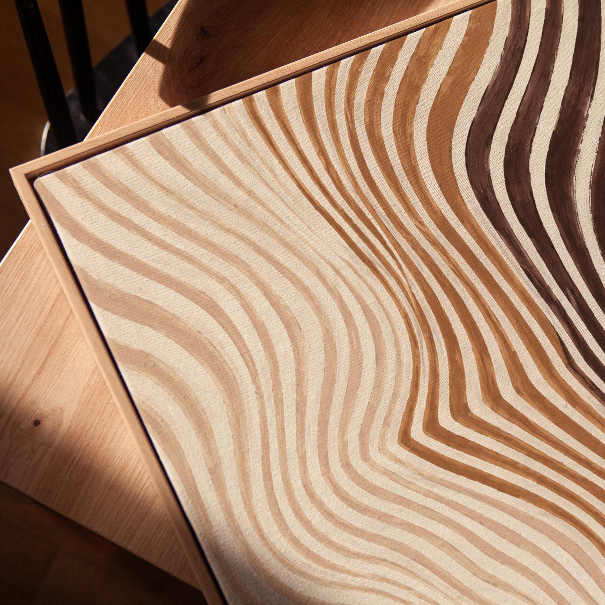 Wavy line pattern fading from beige to rust and brown, canvas print in a warm, minimally styled interior