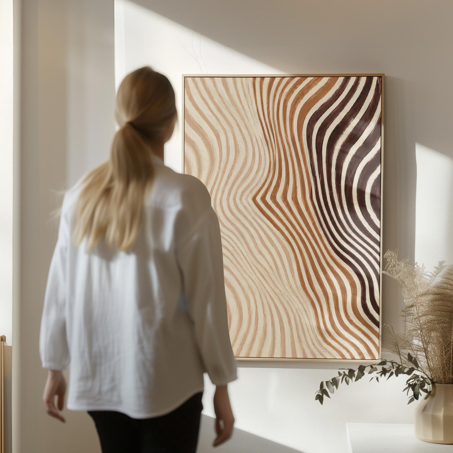 Wavy line pattern fading from beige to rust and brown, canvas wall art on a quiet wall in a considered interior