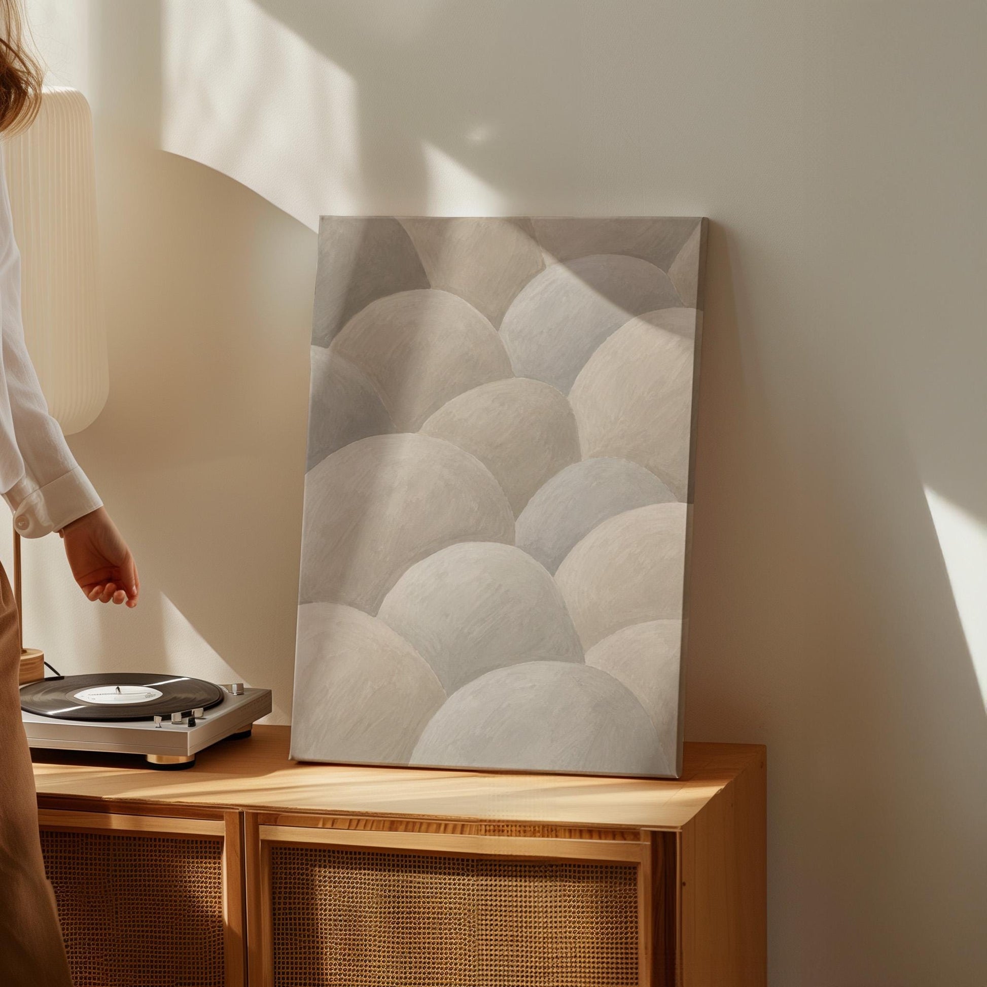 Rows of soft dome shapes in stone gray and beige, canvas print hanging in a calm, modern living space