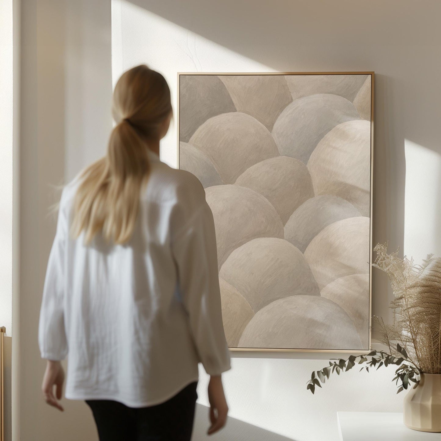 Rows of soft dome shapes in stone gray and beige, canvas wall art presented in a light, minimal room