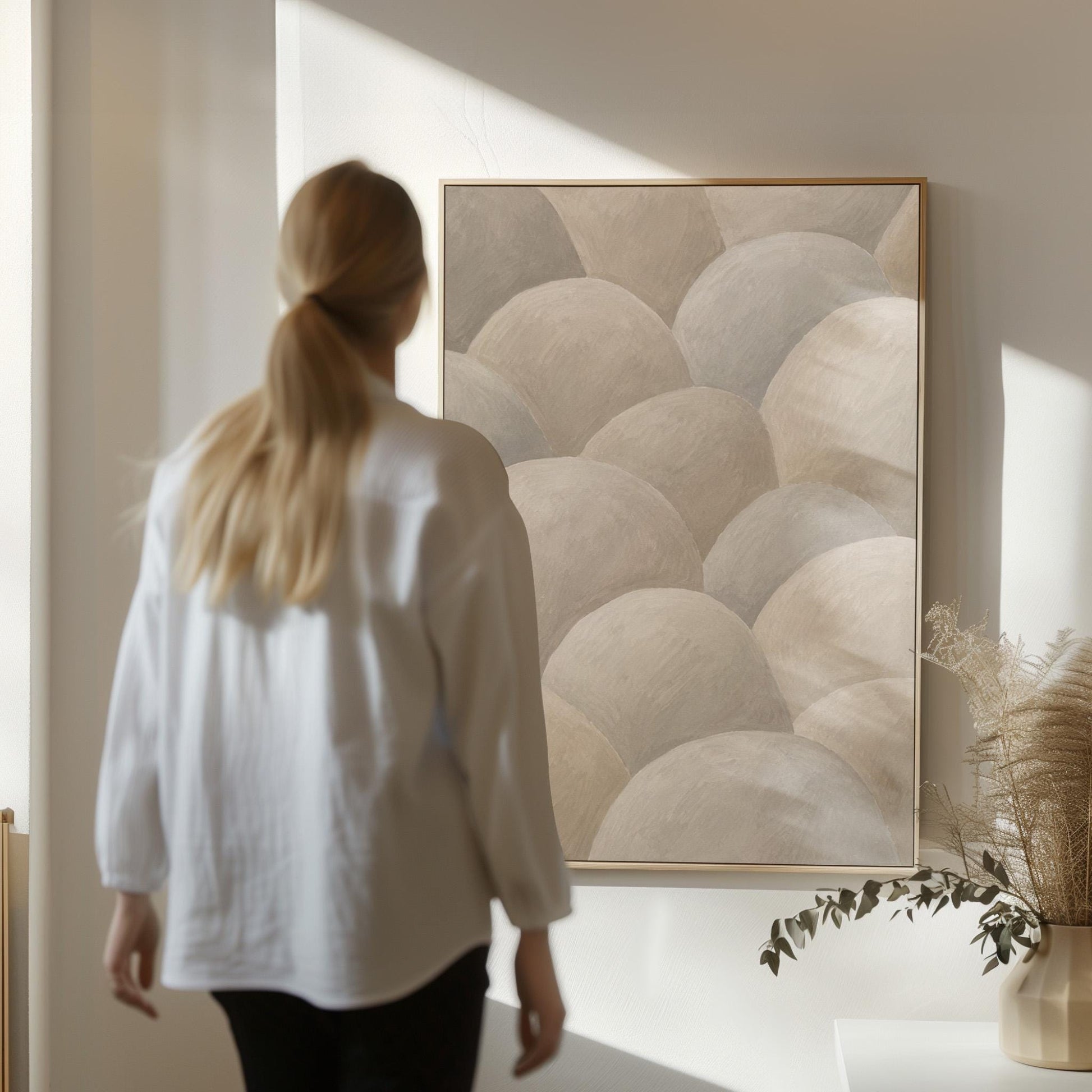Rows of soft dome shapes in stone gray and beige, canvas wall art presented in a light, minimal room
