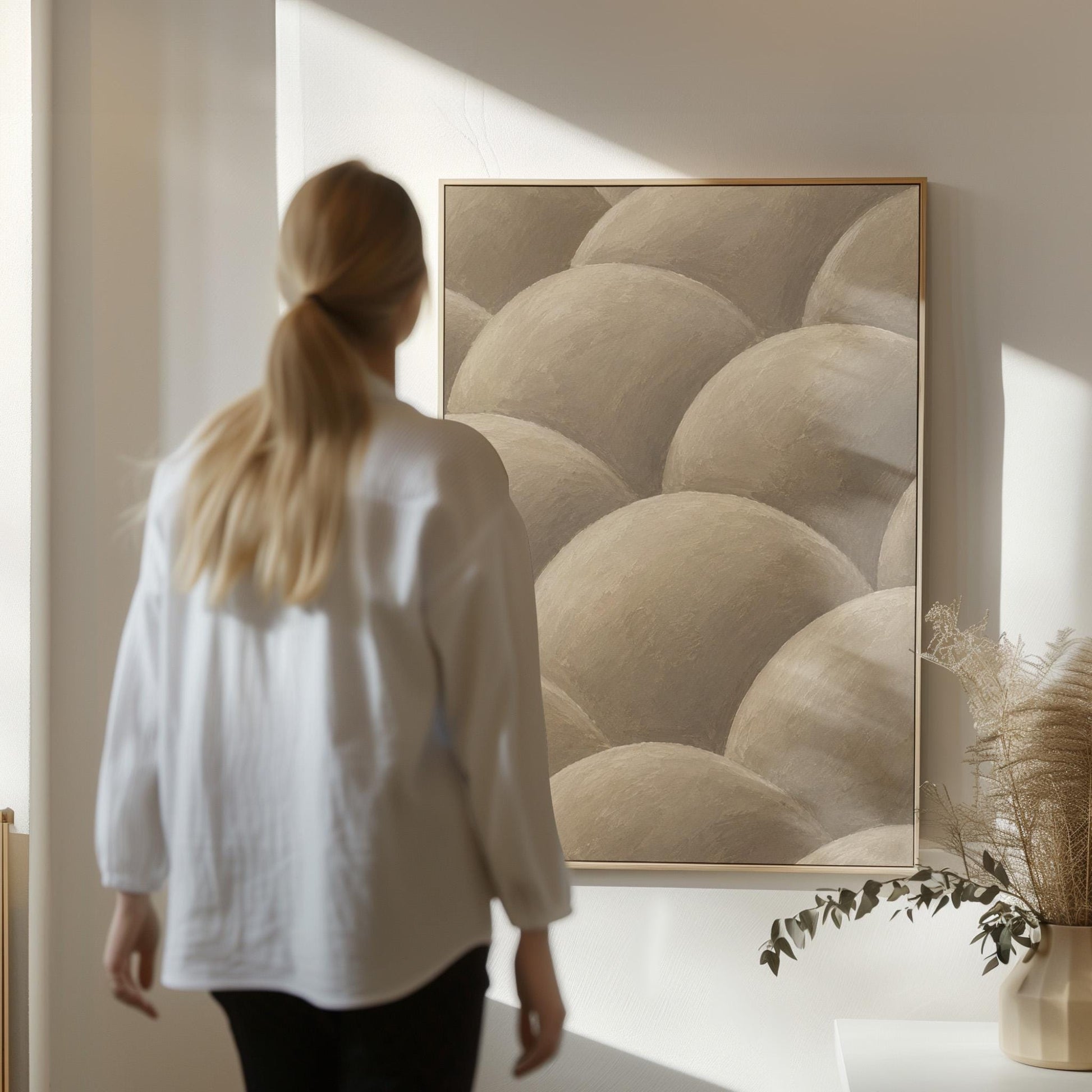 Rows of shaded dome shapes in deep taupe, canvas print on a quiet wall in a considered interior