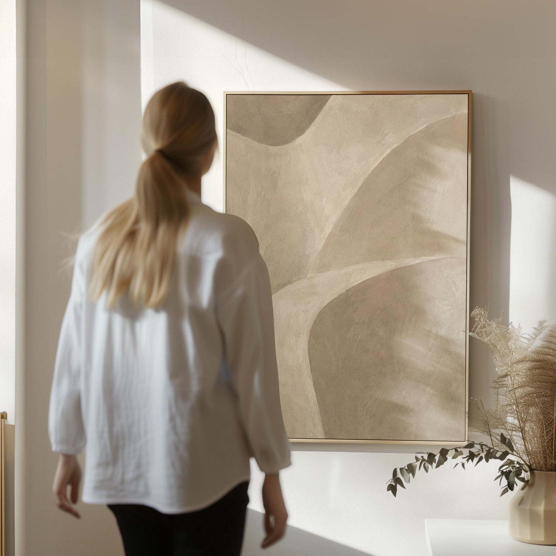 Minimal soft curved lines crossing taupe field, canvas wall art hanging in a calm, modern living space