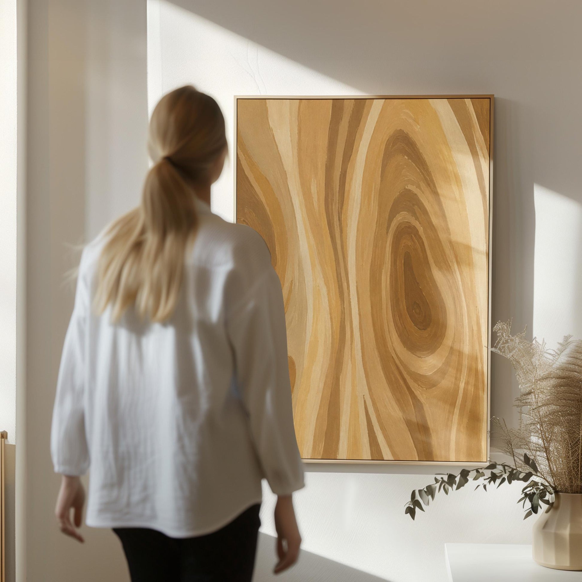 Concentric swirling lines in amber and caramel, canvas print styled against a soft white wall