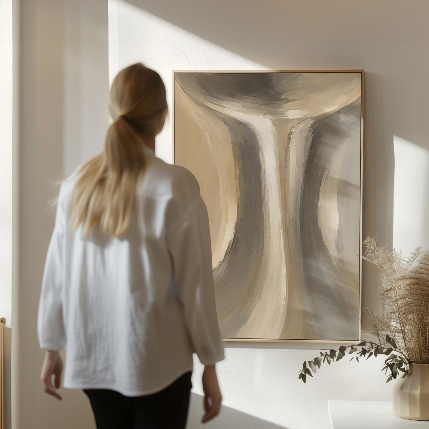 Elegant hourglass curve form in gray and taupe, canvas print displayed on a neutral wall in a styled interior