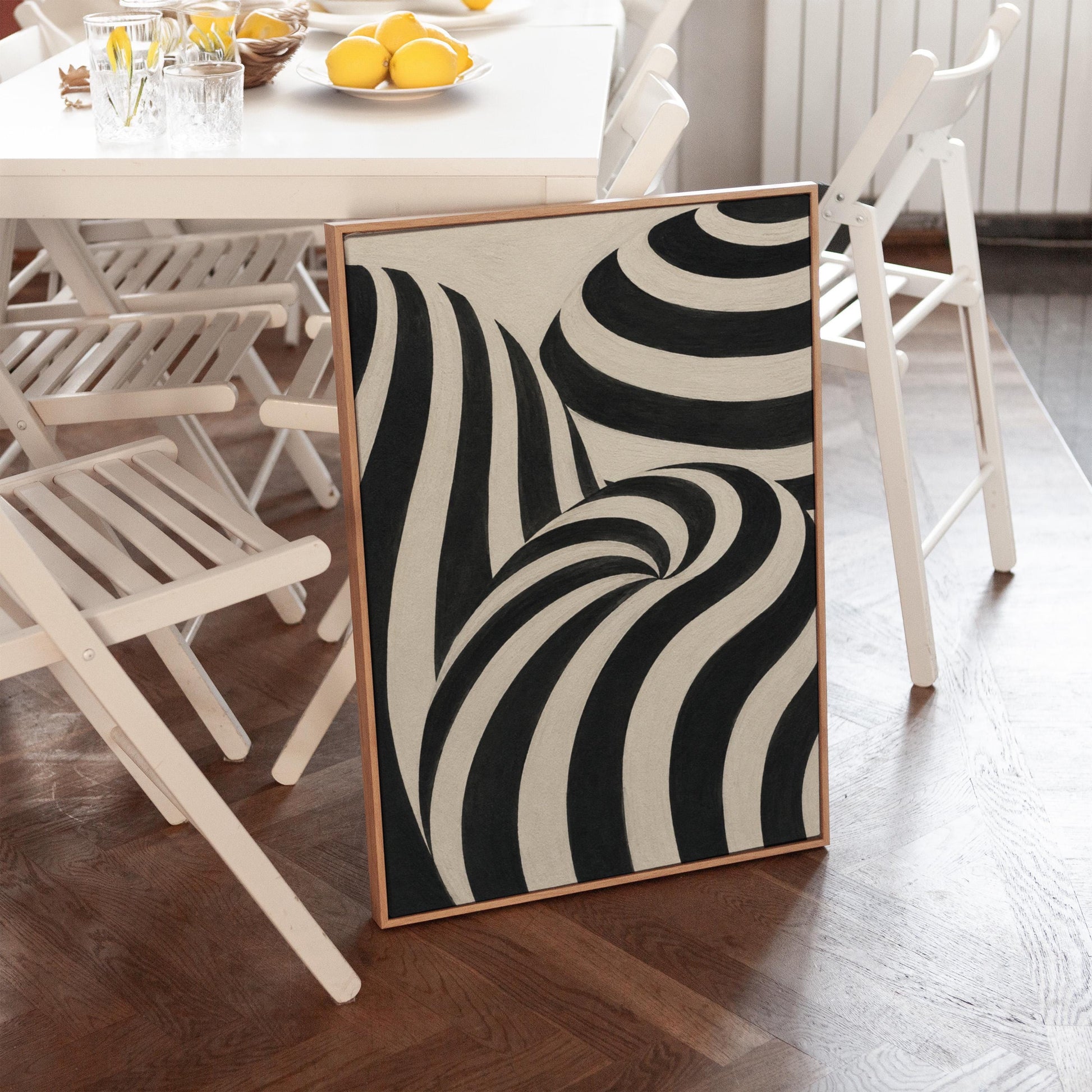 Swirling black and white striped forms, canvas print seen in a warm interior with natural light