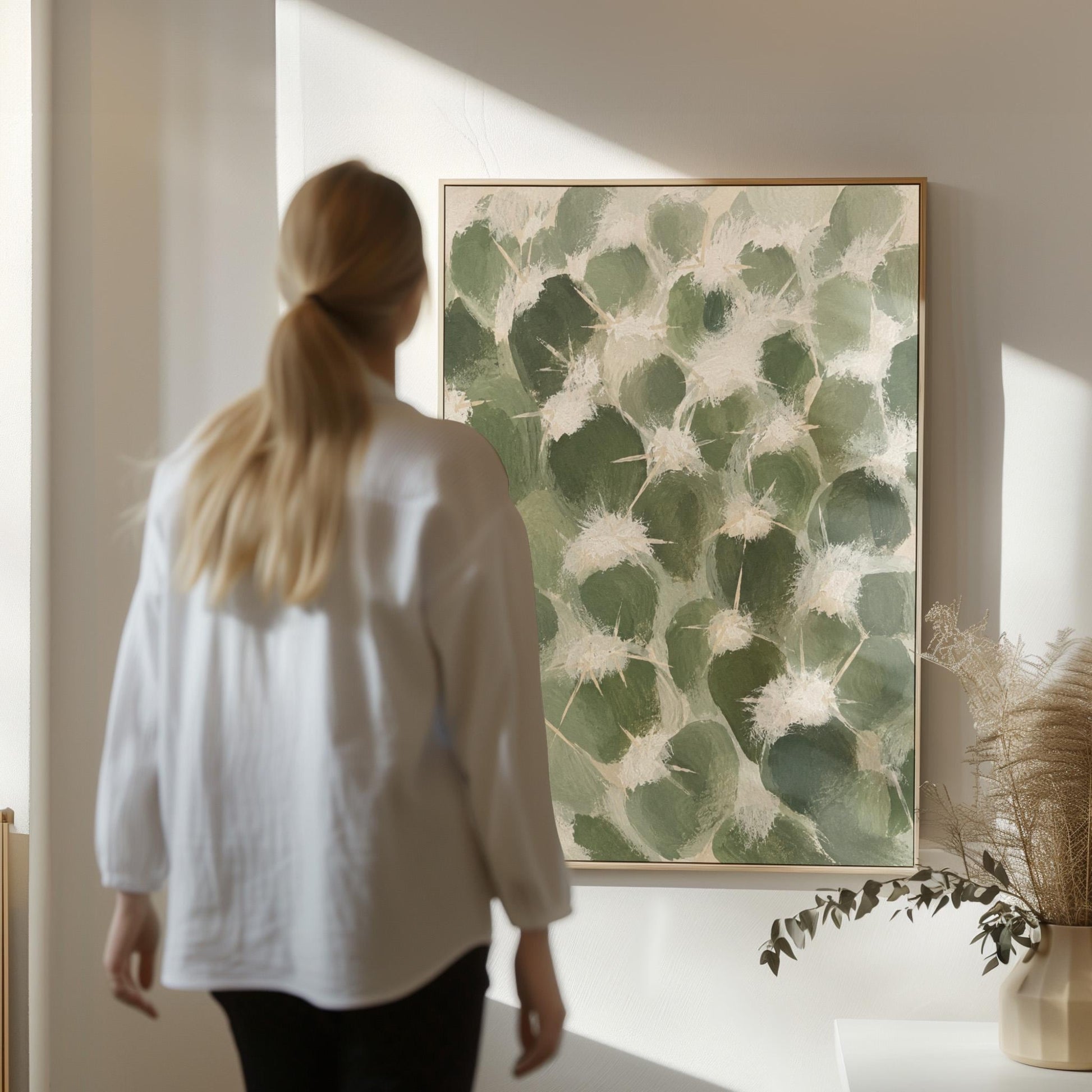Cactus pads pattern with pale spines in sage green, canvas wall art seen in a warm interior with natural light