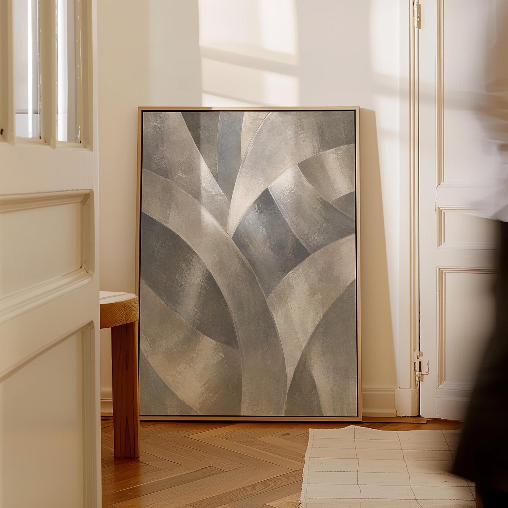 Crossing curved silver bands in graceful motion, canvas wall art on a quiet wall in a considered interior