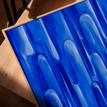 Vertical cobalt streaks like flowing rain, canvas print in a warm, minimally styled interior