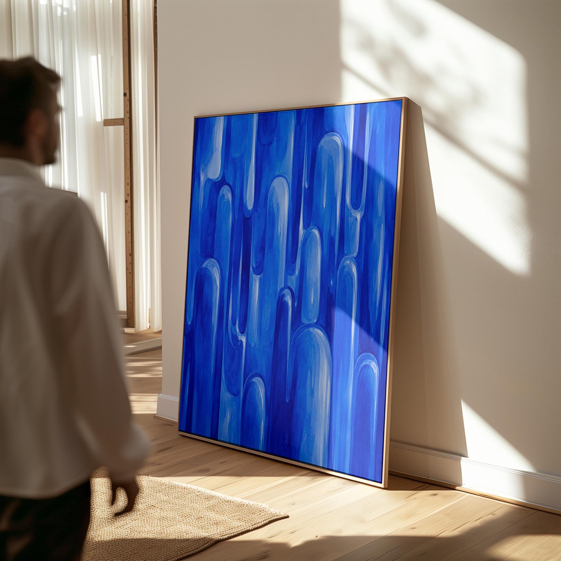 Vertical cobalt streaks like flowing rain, canvas print seen in a warm interior with natural light