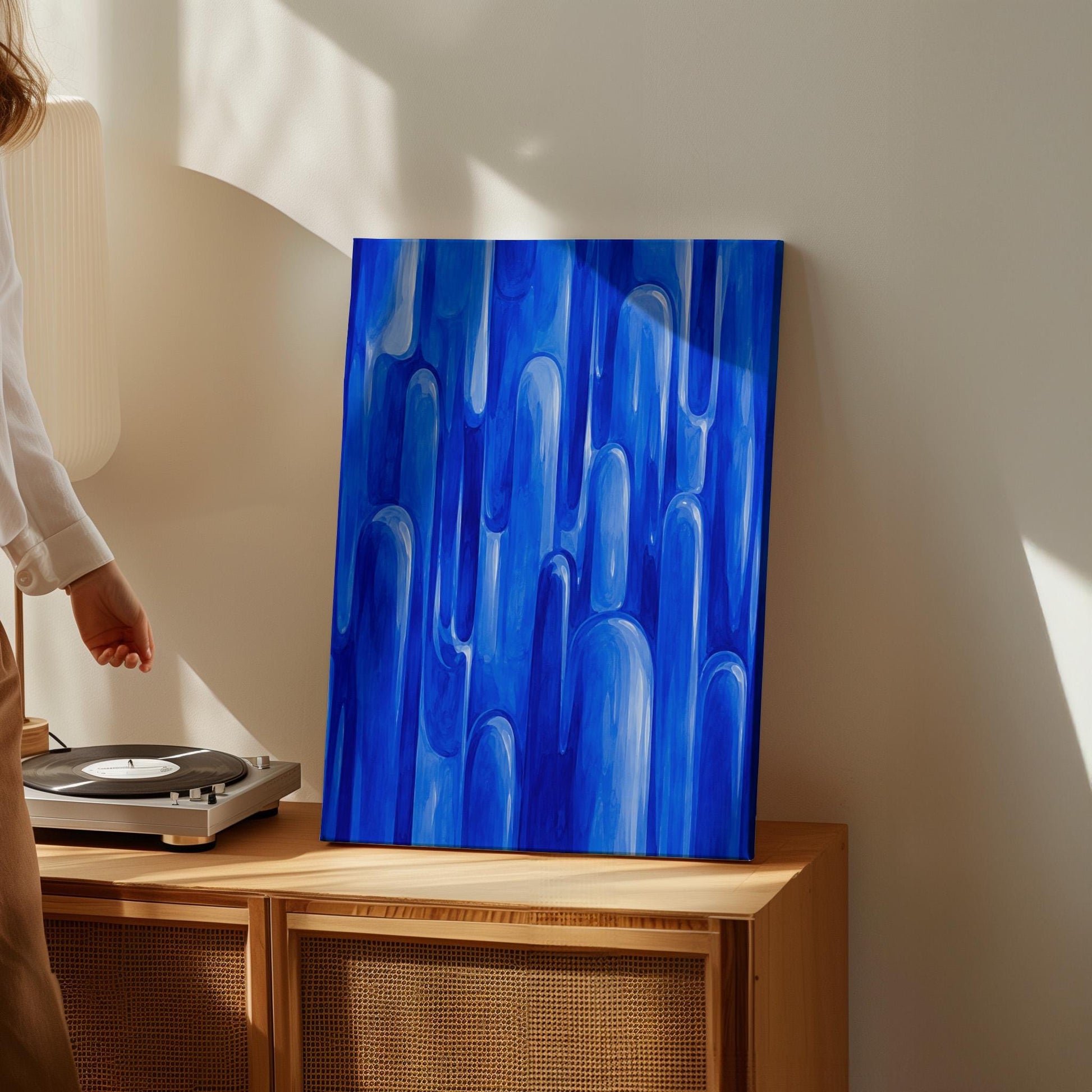 Vertical cobalt streaks like flowing rain, canvas wall art hanging in a calm, modern living space