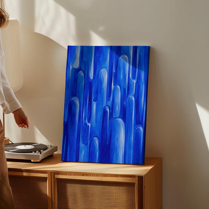Vertical cobalt streaks like flowing rain, canvas wall art hanging in a calm, modern living space