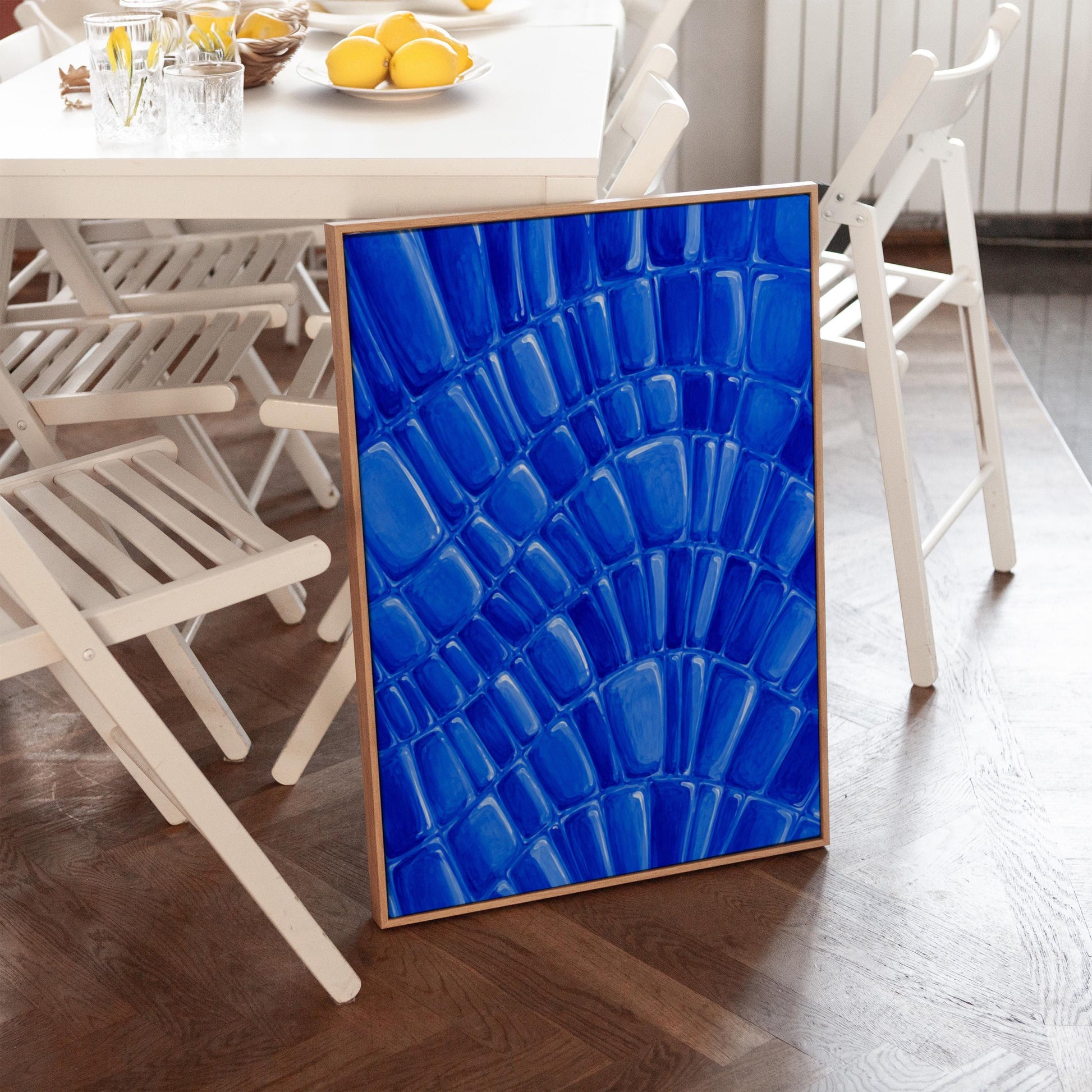Fan arcs of cobalt mosaic pebbles, canvas print hanging in a calm, modern living space