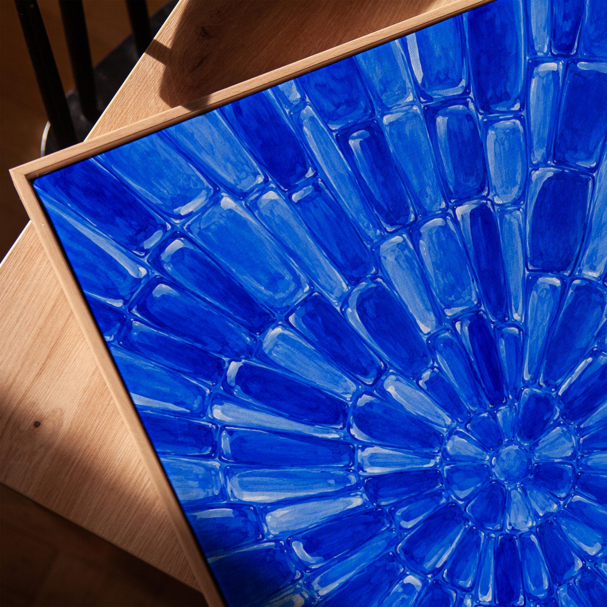 Radial starburst rays in electric cobalt blue, canvas print in a warm, minimally styled interior