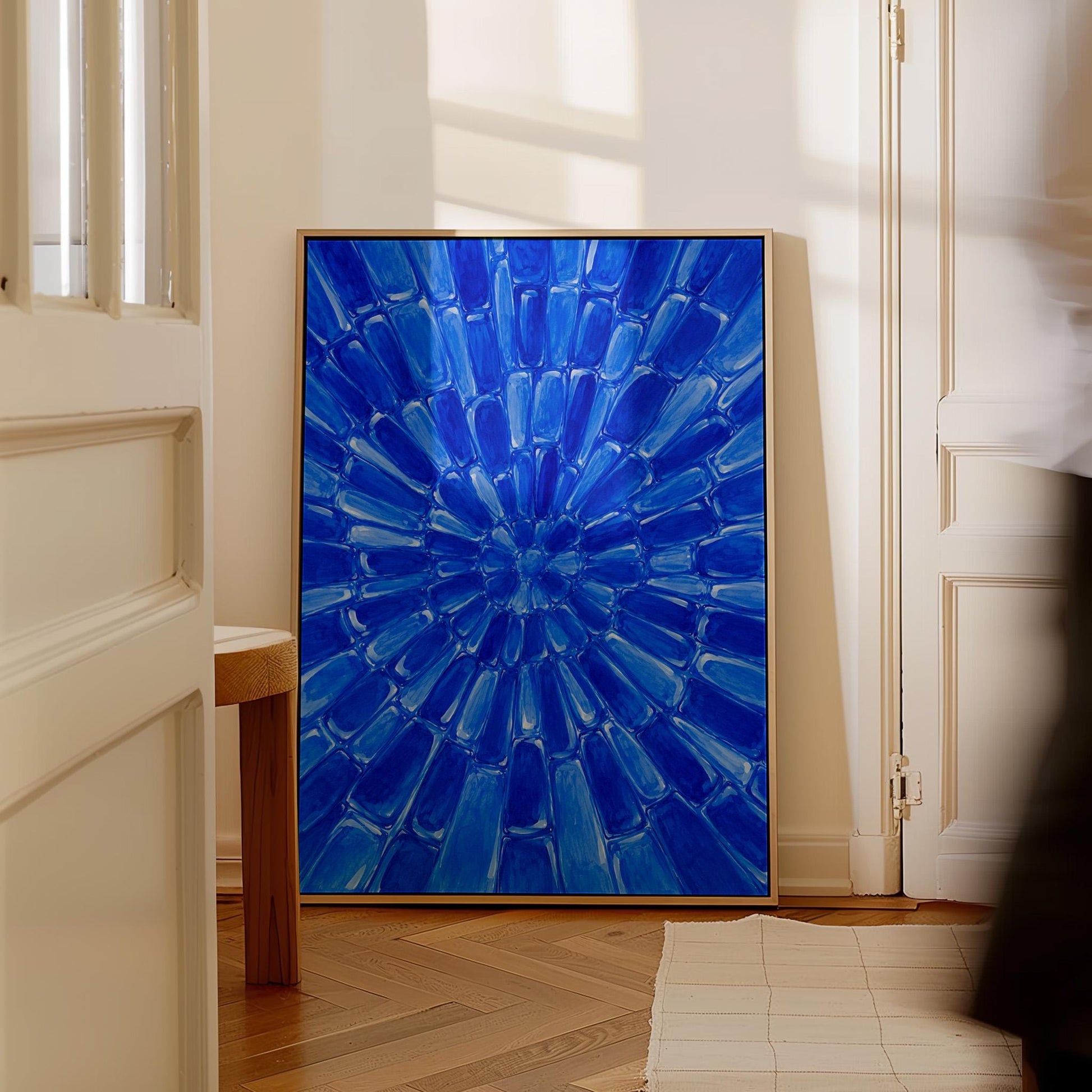 Radial starburst rays in electric cobalt blue, canvas wall art hanging in a calm, modern living space
