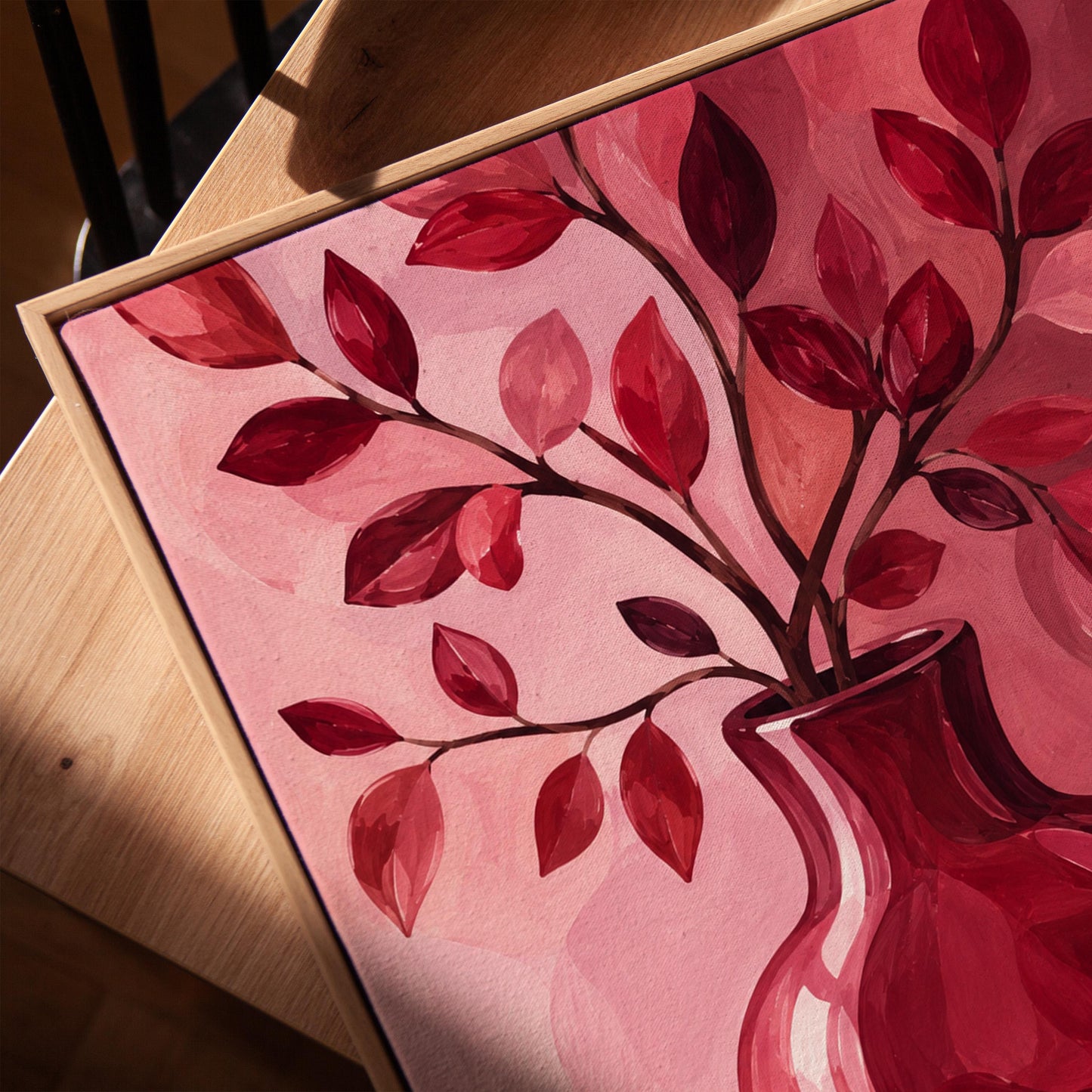 Curvy red vase with leafy branch in burgundy tones, canvas print in a warm, minimally styled interior