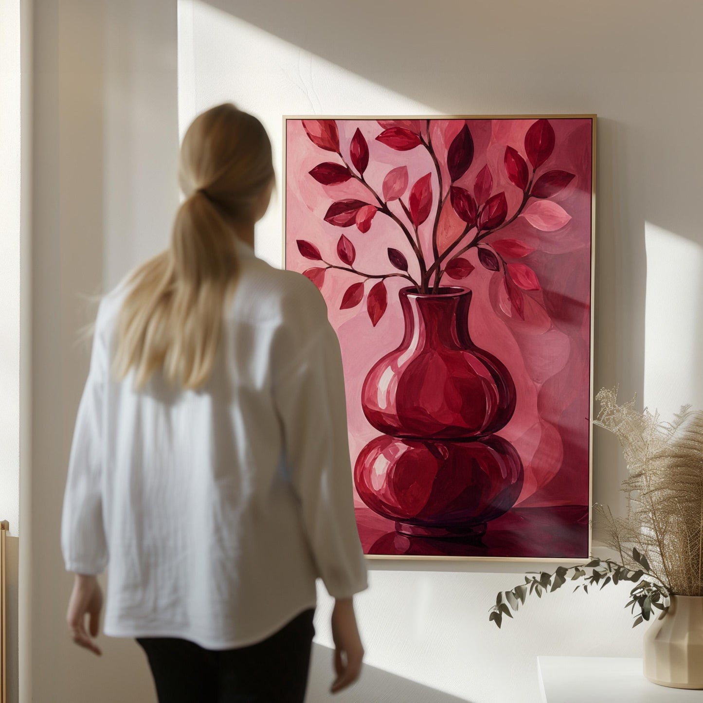 Curvy red vase with leafy branch in burgundy tones, canvas print shown to scale in a furnished room