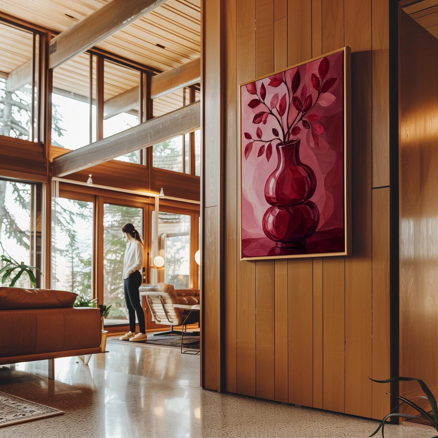 Curvy red vase with leafy branch in burgundy tones, canvas print displayed on a neutral wall in a styled interior