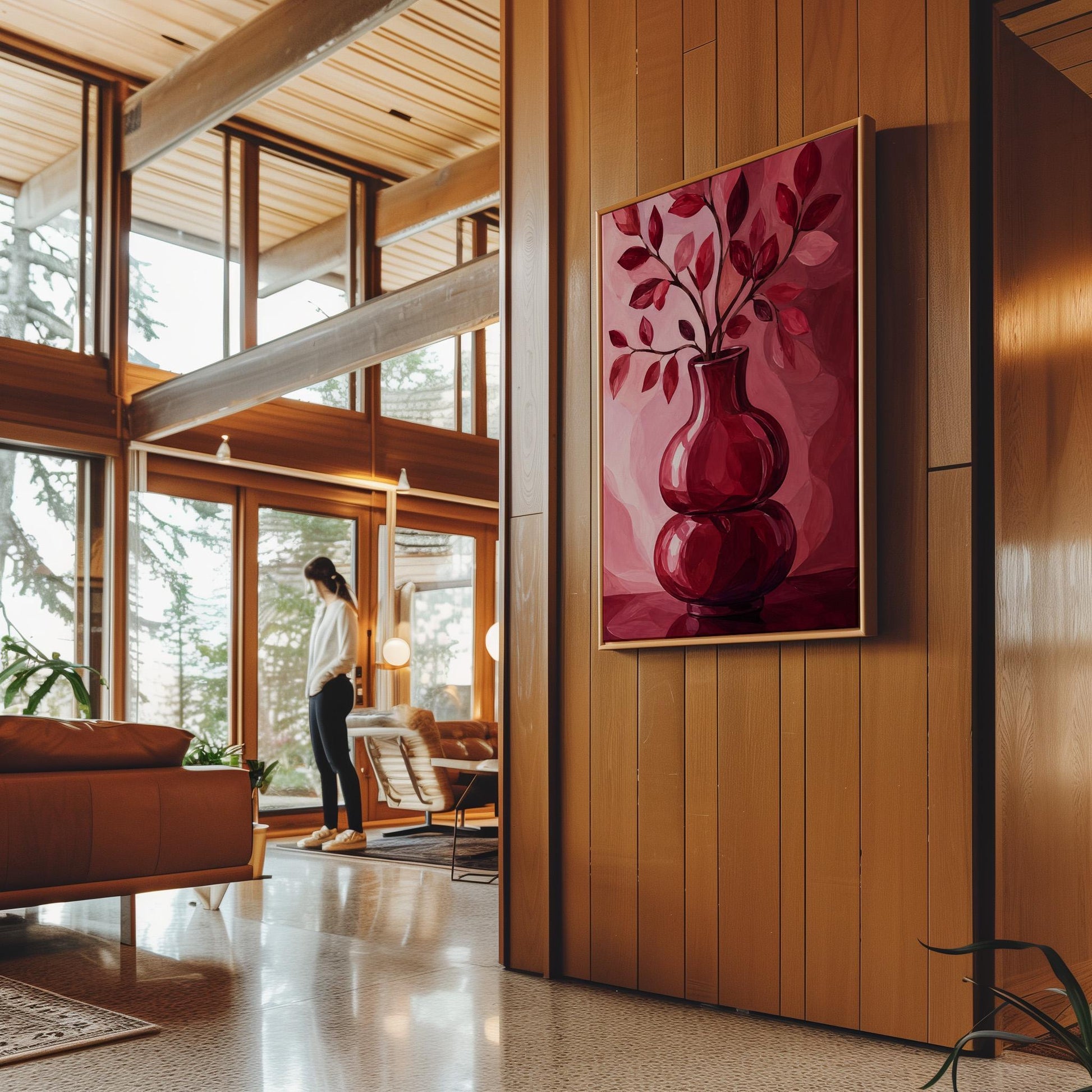 Curvy red vase with leafy branch in burgundy tones, canvas print displayed on a neutral wall in a styled interior